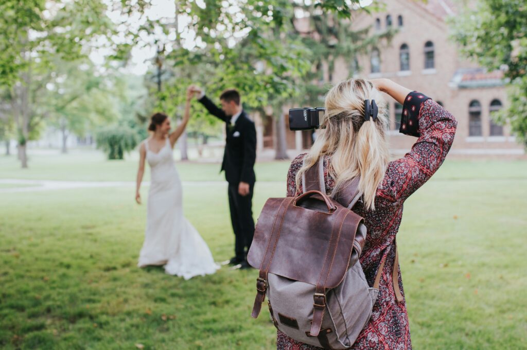 A wedding photographer that needs a standout wedding photographer brand taking a photo of a couple